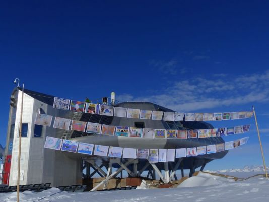 De tekeningen van de leerlingen wapperen in de wind aan het Princess Elisabeth Antarctica-station!