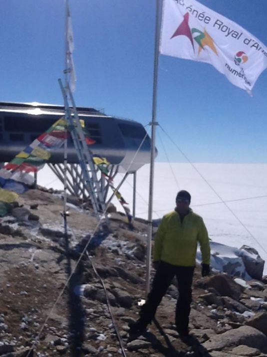 Een echte vlag van het Athénée Royal d'Ans wappert nabij het Princess Elisabeth Antarctica station.