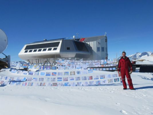 Johnny poseert voor de vlaggen die dit jaar zijn verzonden naar Princess Elisabeth Antarctica.