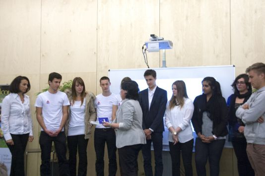 Nathalie Van Isacker remet les prix à Christine Chatzigiannis et sa classe de l'Institut des Sacrés-Coeurs, qui remportent la deuxième place du concours.