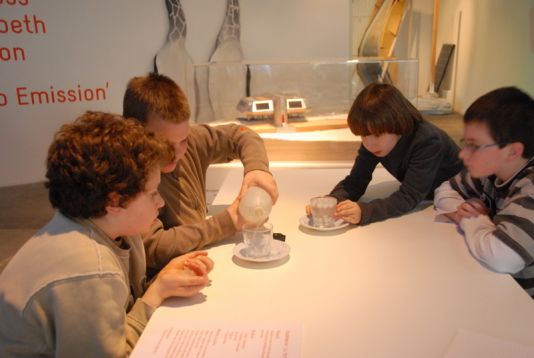 Students conducting an experiment to see the impact that both melting sea ice and melting land ice have on water levels