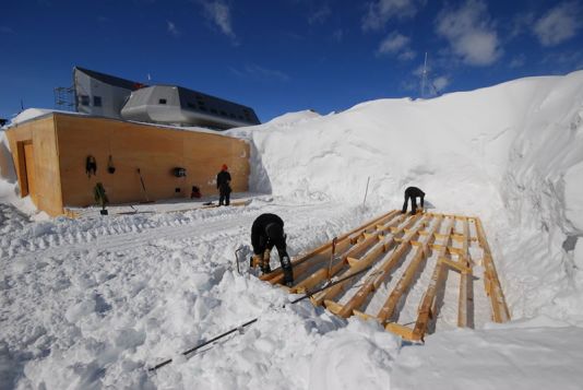 La pose des fondations du garages. Pas de chape, pas de béton. Une couche de bois, une couche de neige, et ainsi de suite...