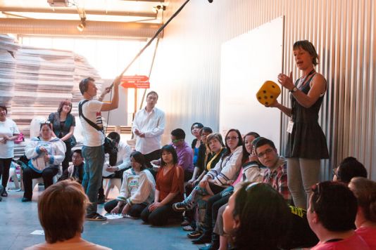 Sandra initiates and directs the cultural exchange between the students by rolling the dice.