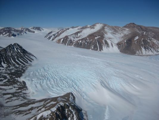 Antarctica is een adembenemende plaats om te werken! Een gletsjer slingert zich door de bergen.
