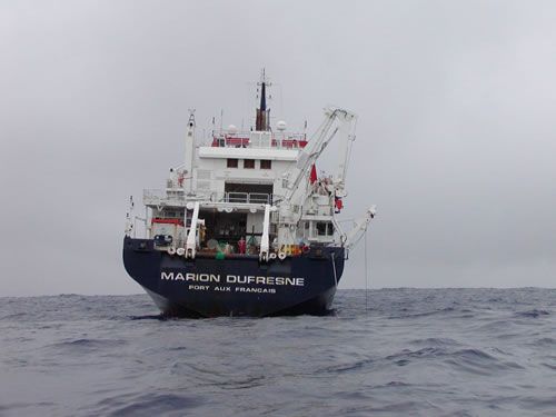 Vue de l’arrière du Marion Dufresne. On peut distinguer un forage en cours à tribord. Les containers d’échantillons et d’analyse sont rangés à l’abri de la plate-forme hélicoptère.